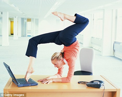 person doing yoga and typing on laptop with their feet