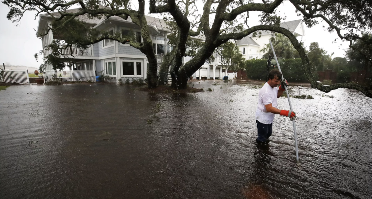 person outside flooded house