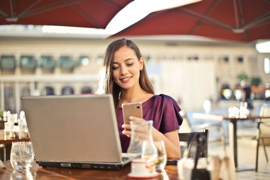 person using a phone and laptop