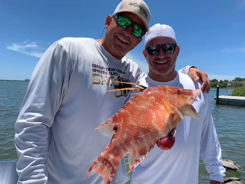 two people holding up a fish